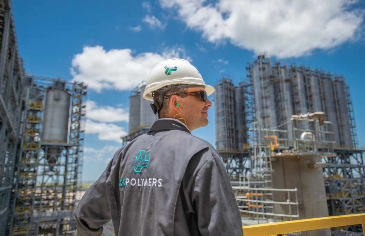 Showing a man working at a refinery wearing CC Polymers coveralls.