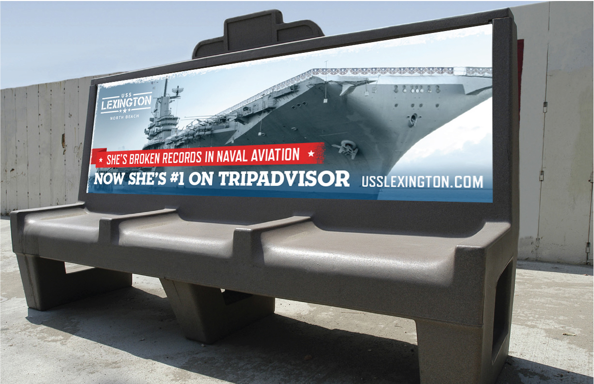 Showing the an ad for the USS Lexington painted on a park bench.